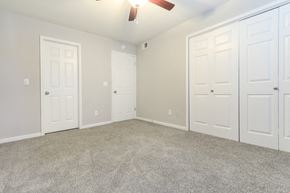 Columbia apartment for rent - an empty bedroom with three doors and a ceiling fan