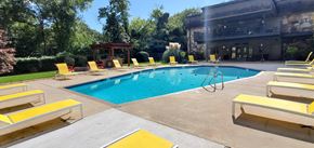 Knoxville apartment for rent - A pool with yellow sun loungers and a wooden gazebo.