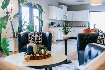 Knoxville apartment for rent - A living room with a black leather chair and a white coffee table.