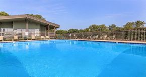Nashville apartment for rent - a large blue pool with chairs and a house