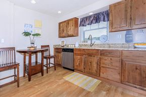 St. Louis townhouse for rent - a kitchen with wooden cabinets and a table with chairs