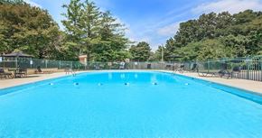 Clarksville apartment for rent - a large blue pool with chairs and a fence around it
