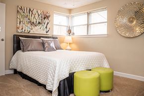 St. Louis apartment for rent - A bedroom with a large bed and a large drum on the wall.