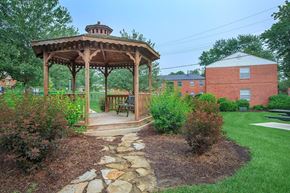 St. Louis apartment for rent - A gazebo is surrounded by a stone pathway and green shrubbery.