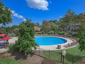 Knoxville apartment for rent - a swimming pool with trees and chairs around it