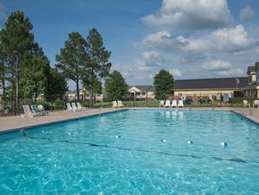 Fort Smith apartment for rent - a swimming pool with chairs and trees in front of a building