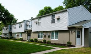 Rochester townhouse for rent - a row of houses with a sidewalk and green grass