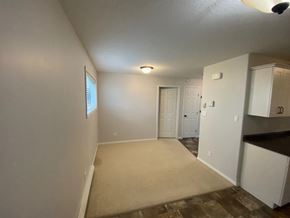 Brandon triplex for rent - the living room and kitchen of an empty house