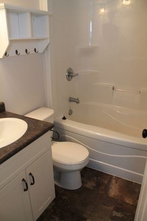 Brandon triplex for rent - a bathroom with a toilet and a tub and a sink