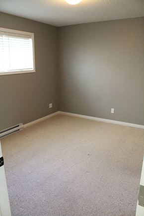 Brandon triplex for rent - a room with a carpeted floor and a window