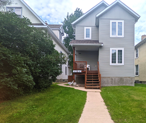 Brandon triplex for rent - the back of a house with a sidewalk in front of it