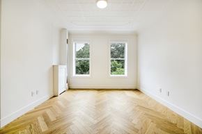 Brooklyn apartment for rent - an empty living room with wood flooring and two windows