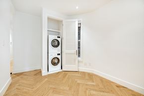 Brooklyn apartment for rent - a living room with a washing machine and a door to a laundry room