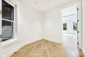 Brooklyn apartment for rent - a living room with white walls and wood flooring and a window