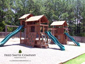 Knightdale townhouse for rent - a playground with three wooden structures and three sets of slides