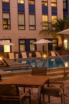 New Orleans apartment for rent - a hotel pool with tables and umbrellas at night