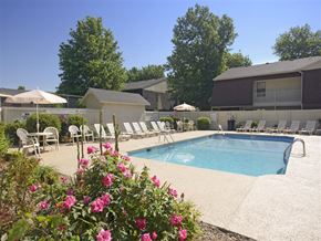 Fayetteville apartment for rent - a swimming pool with chairs and umbrellas next to a building