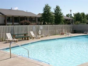 Fayetteville apartment for rent - a swimming pool with chairs and a fence around it