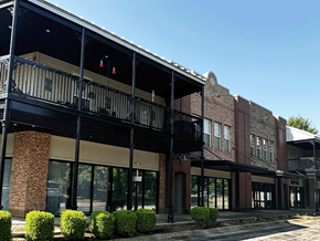 Fayetteville apartment for rent - a brick building with glass windows and a balcony