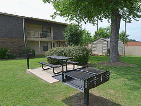 Springdale apartment for rent - a picnic area with a table and a grill in front of an apartment building