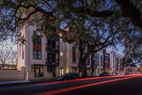 Savannah apartment for rent - a row of apartment buildings on a city street at night
