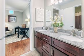 Greenville apartment for rent - a bathroom with two sinks and a mirror and a living room