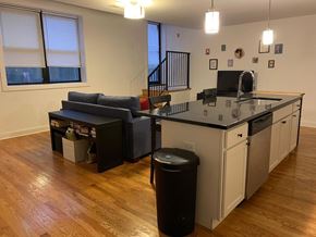 Chicago apartment for rent - an empty living room with a kitchen and a couch