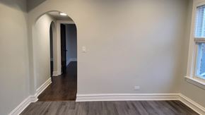 Chicago apartment for rent - A hallway with a wooden floor and white walls.