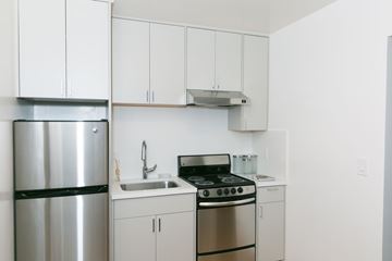 San Francisco apartment for rent - A kitchen with white cabinets and a stainless steel refrigerator.