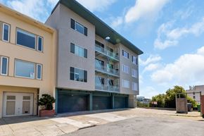 San Francisco apartment for rent - A modern two-story apartment building with a garage door and balconies.