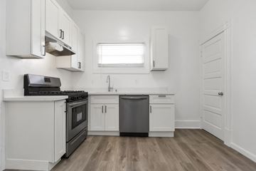 San Francisco apartment for rent - A kitchen with white cabinets and a black stove top oven.