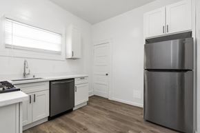 San Francisco apartment for rent - A kitchen with a stainless steel refrigerator and white cabinets.