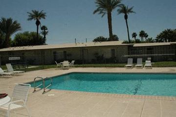 Cathedral City apartment for rent - a swimming pool with chairs and chairs around it