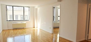 New York apartment for rent - an empty living room with a wood floor and a window
