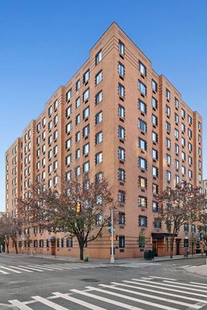 New York apartment for rent - a tall brick building on the corner of a city street