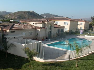 Santee apartment for rent - a house with a swimming pool in front of some apartments