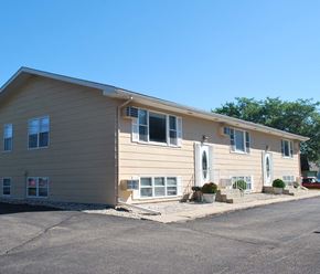 Mankato apartment for rent - a tan house with white windows and a driveway