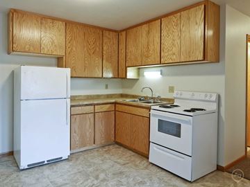 East Grand Forks apartment for rent - a kitchen with white appliances and wooden cabinets