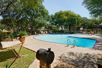 Swimming pool with surrounding patio and safety fencing