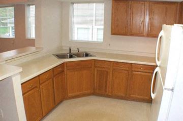 St. Paul townhouse for rent - a kitchen with wooden cabinets and a sink and a refrigerator