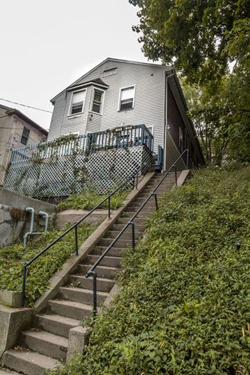 New Haven apartment for rent - A staircase with a metal railing leads up to a house.