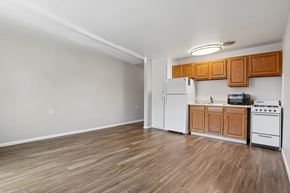 Denver apartment for rent - A kitchen with wooden cabinets and white appliances.