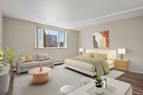 Denver apartment for rent - A modern bedroom with a large bed and a grey carpet.