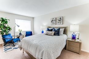 Huntsville apartment for rent - A bedroom with a large bed and a blue chair.