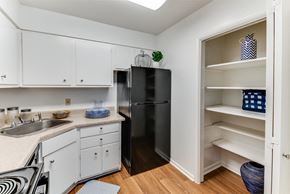 Huntsville apartment for rent - A kitchen with white cabinets and a black fridge.