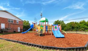 Huntsville apartment for rent - A playground with a blue slide and a green roofed structure.