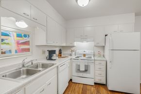 Huntsville apartment for rent - A white kitchen with a stove, sink, and refrigerator.