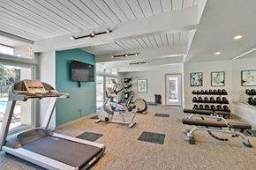 Hayward apartment for rent - A well-equipped home gym with a treadmill, exercise bikes, and weights.