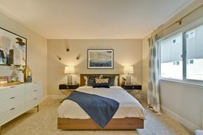 Hayward apartment for rent - A bedroom with a bed, nightstands, and a painting on the wall.