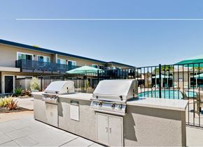 Hayward apartment for rent - A row of outdoor BBQs are lined up next to a pool.